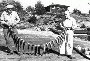 Ernest Peterkin and a friend proudly displaying a catch of fish. 